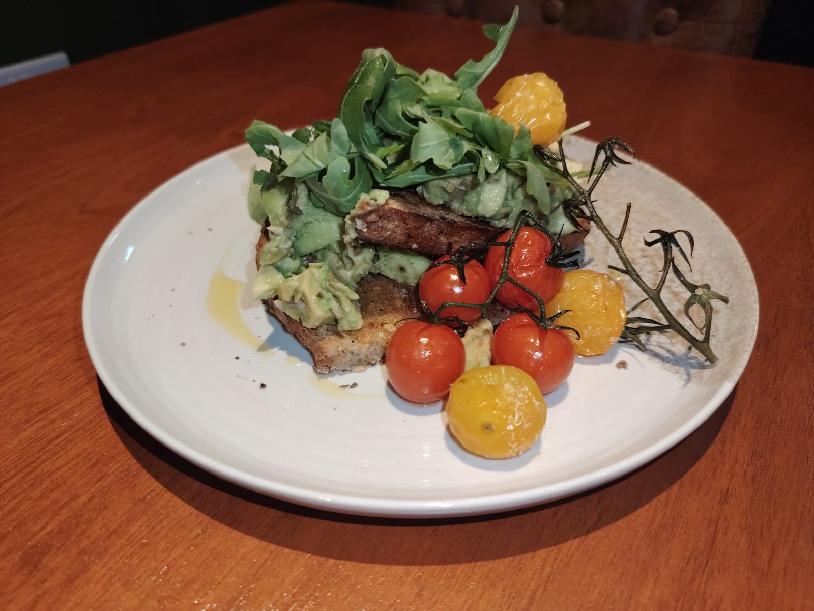 Avocado toast with rocket and roasted tomatoes at Cosy Cafe and Kitchen